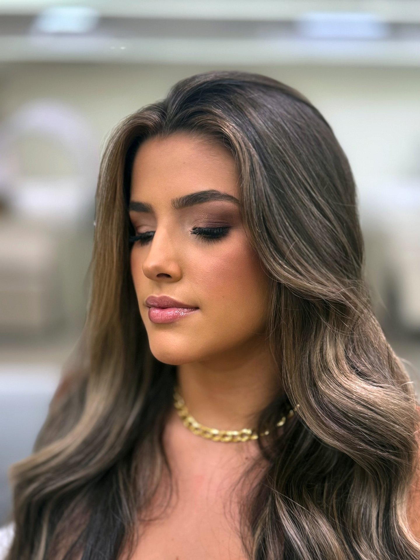 Cliente com cabelo longo com mechas carameladas em ondas e maquiagem glamourosa, produção do Nix Beauty Salon, no Shopping Palladium, em Curitiba