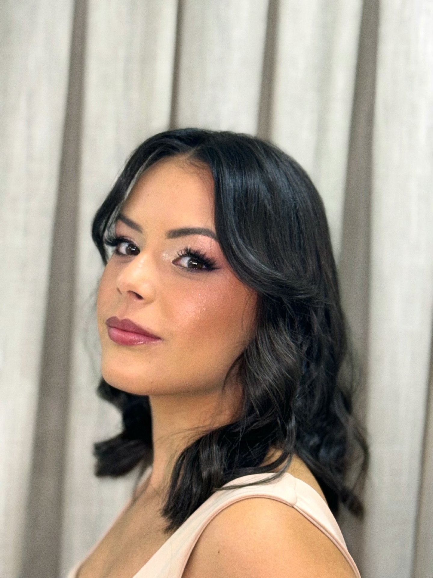 Cliente com cabelo ondulado na altura dos ombros com franja e maquiagem completa, produção do Nix Beauty Salon, no Shopping Palladium, em Curitiba